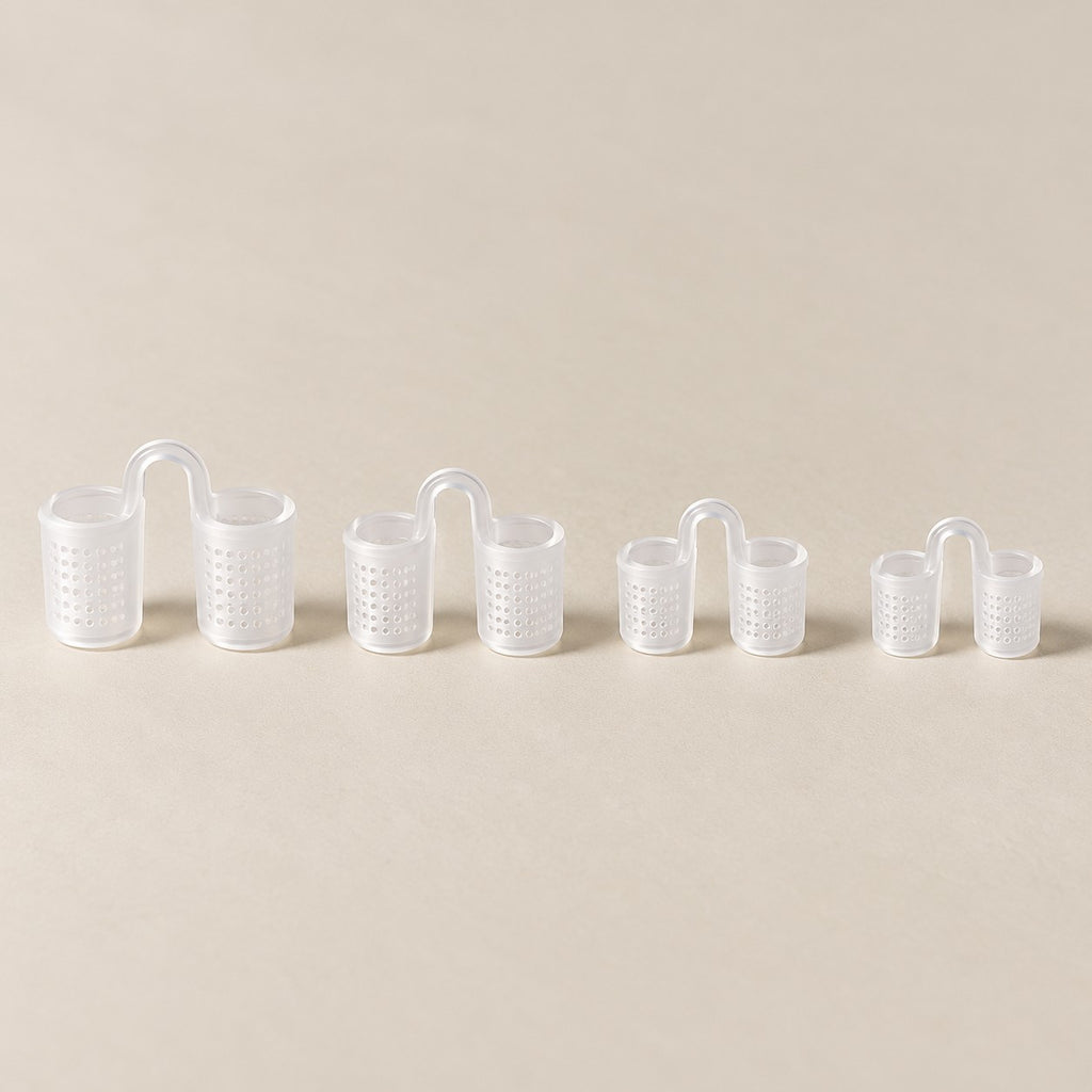 Os quatro tamanhos do dilatador nasal de silicone transparente, com telinha, do maior ao menor, sobre fundo claro.