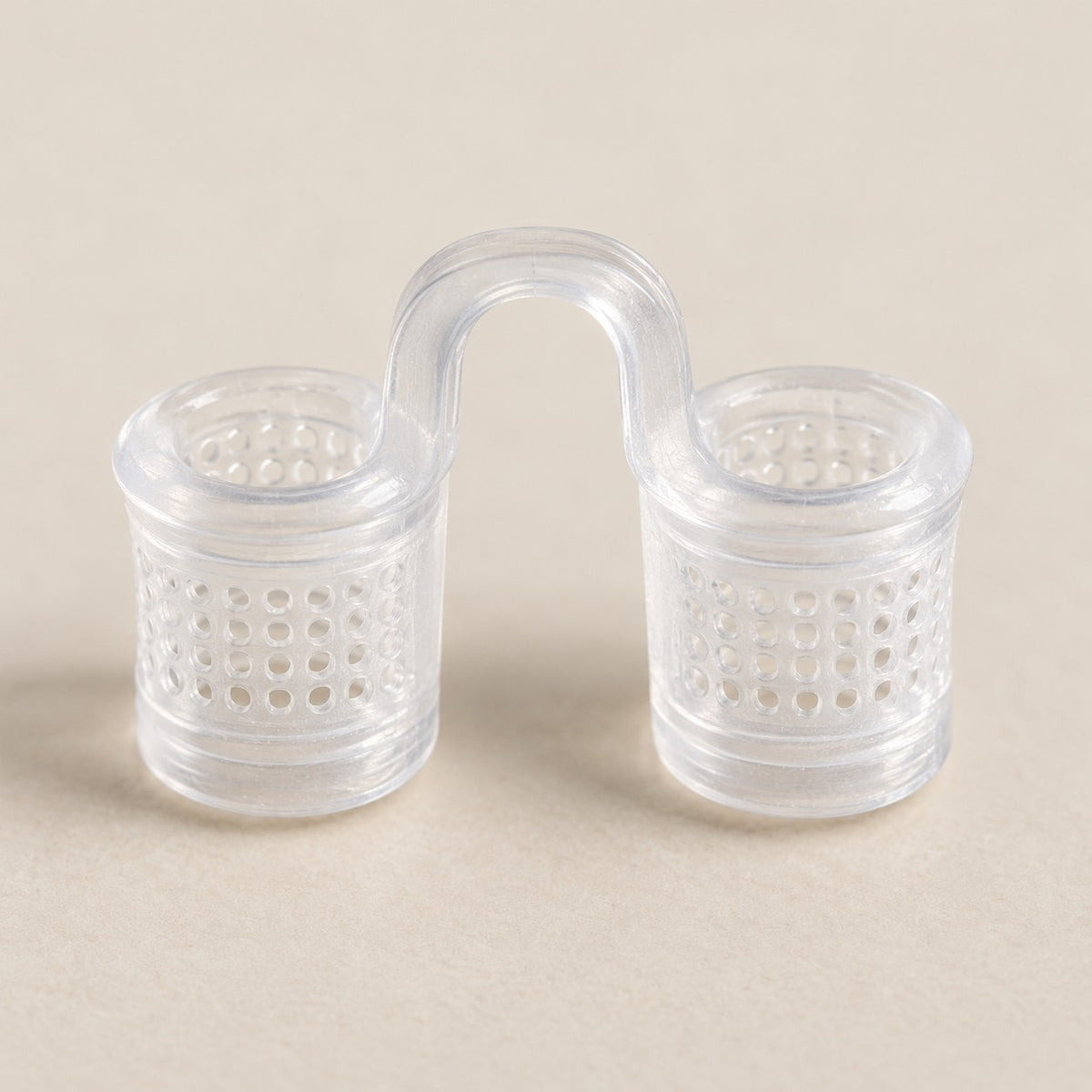 Detalhe do dilatador nasal de silicone transparente: os dois cilindros com telinha e a ponte em U.
