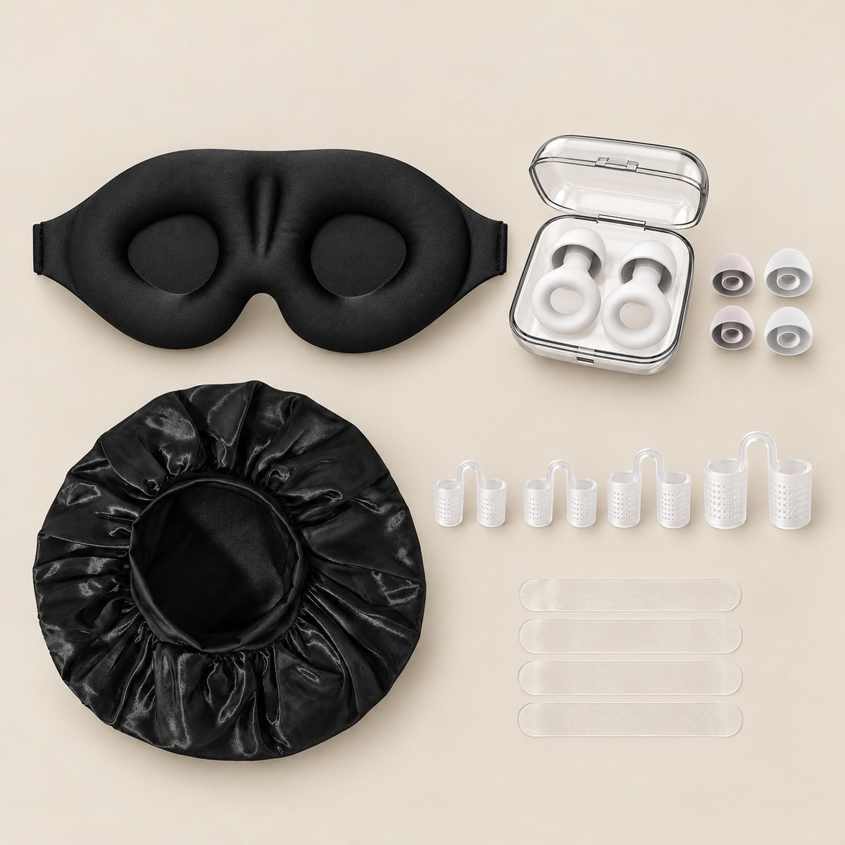 Tapa olho 3D preto, protetores auriculares brancos no estojo transparente com ponteiras reservas, touca de cetim preta, 4 dilatadores nasais e 4 fitas nasais transparentes, sobre fundo cor de papel