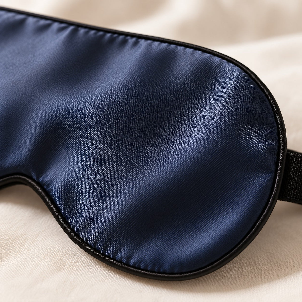 Detalhe do tecido liso e do debrum da máscara de dormir de seda azul-marinho